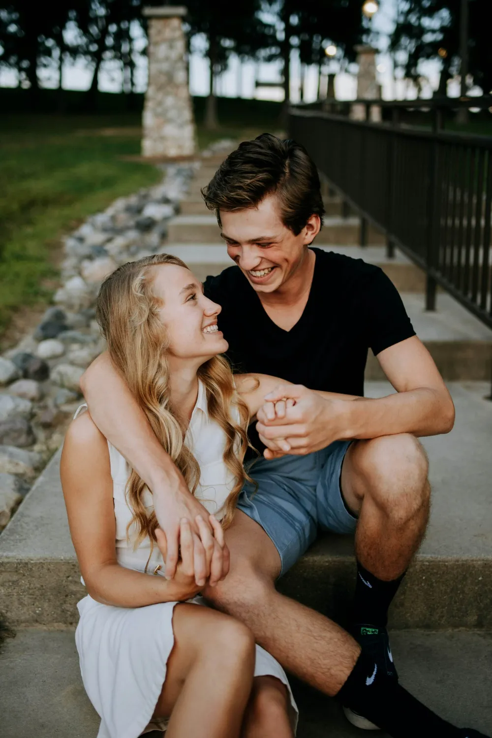 Casal sorrindo e de mãos dadas em uma escadaria
